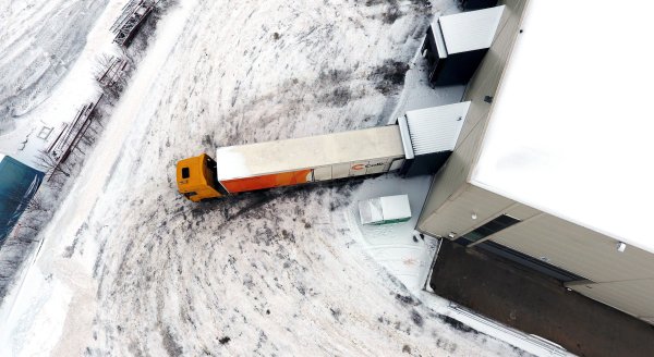 Looking over a branded ColliCare trailer from above parked to the storage, loading and unloading goods 