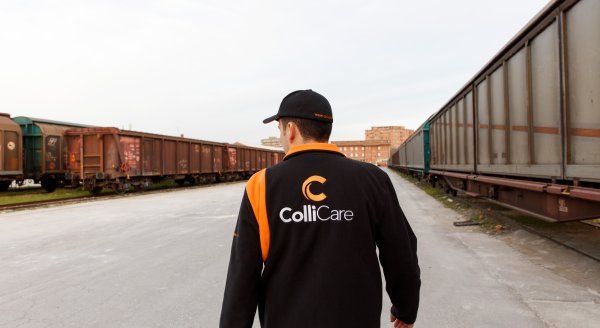 An employee in branded clothes from behind, walking towards the parked train at the railway station